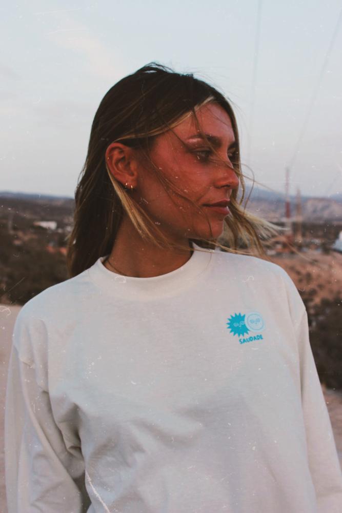 Portrait de Nour au vent, logo Saudade bleu sur le devant du tee-shirt