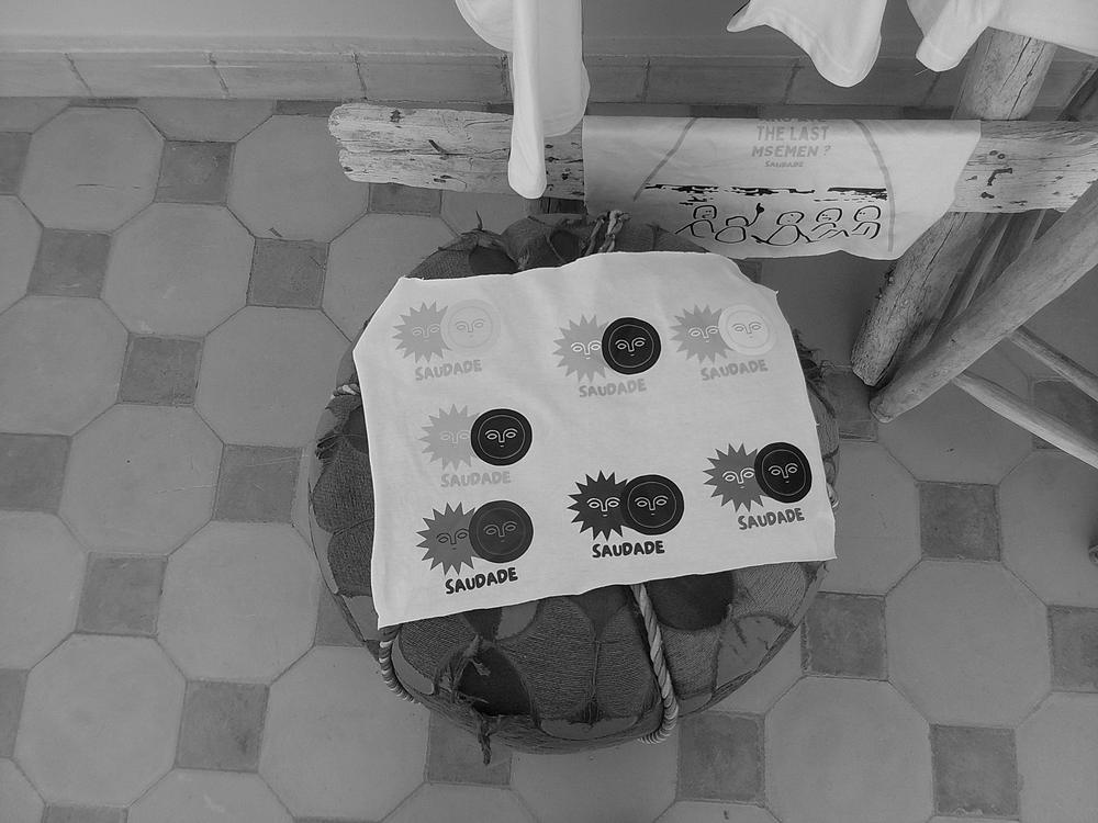 Planche de logos Saudade sur un pouf, en noir et blanc