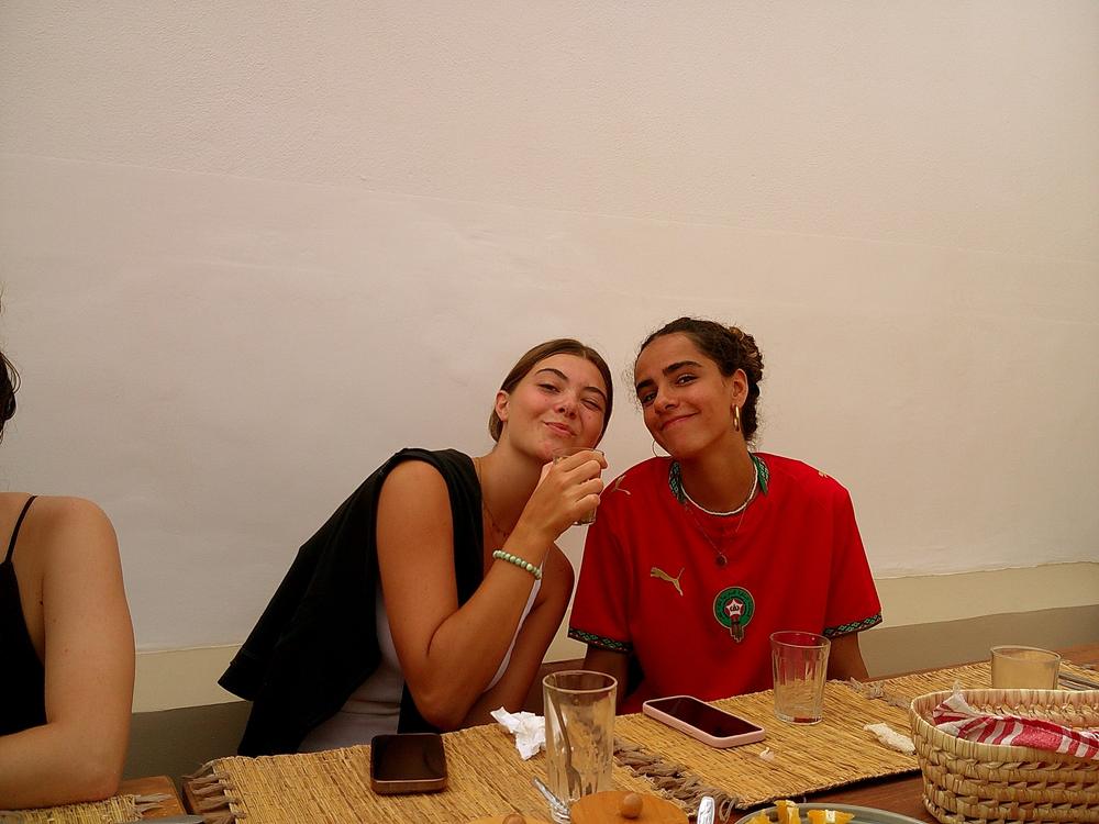 Deux amies souriantes à table, thé à la menthe
