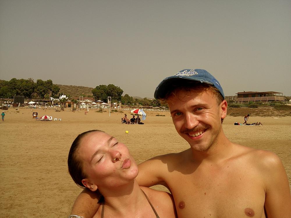 Un couple sur la plage, grimace et grand sourire