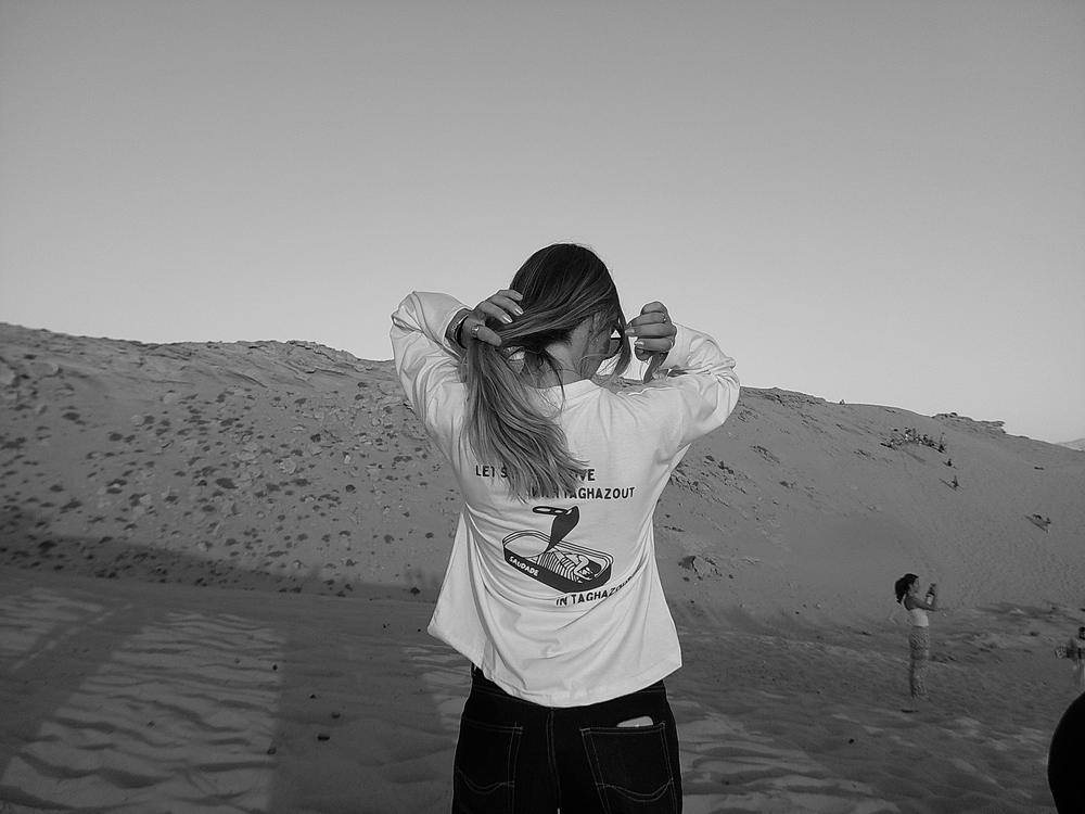 Tee-shirt Let’s fall in love with Taghazout vu de dos dans les dunes, en noir et blanc