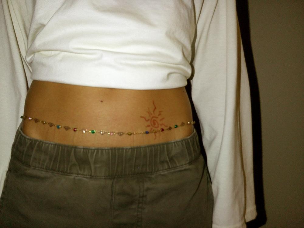 Ceinture de perles et soleil au henné sur le ventre