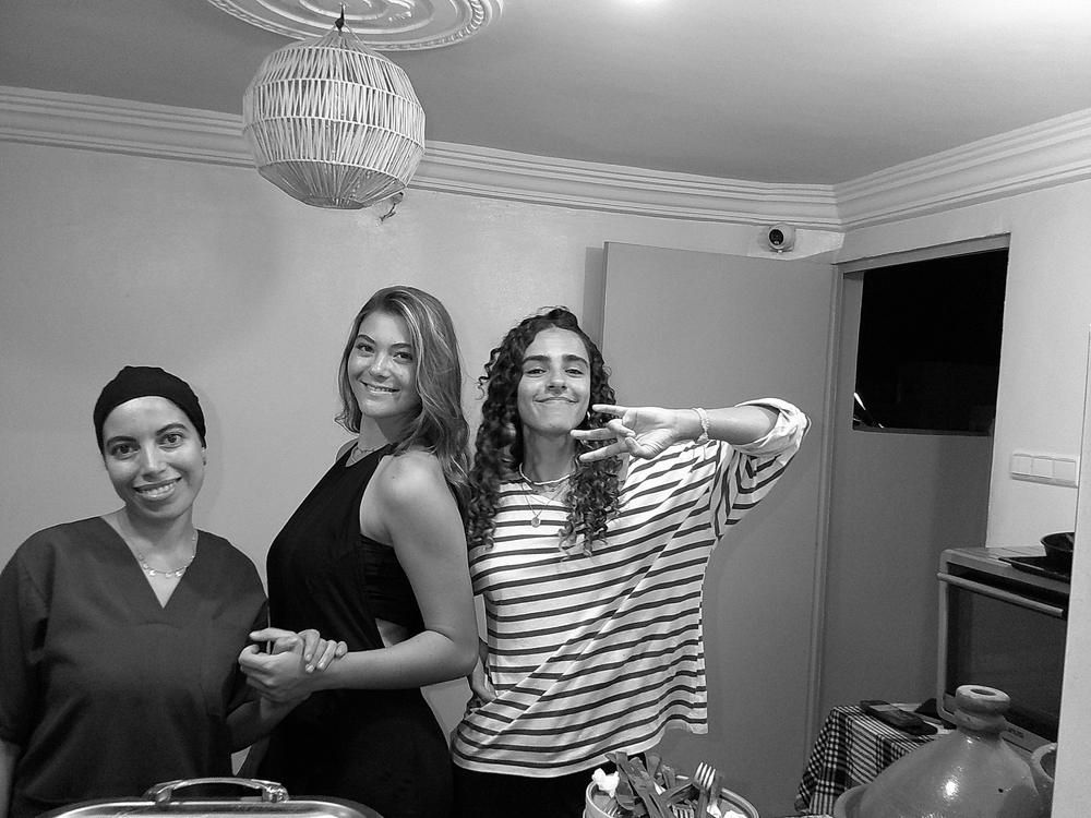 Trois amies posent dans une cuisine, en noir et blanc