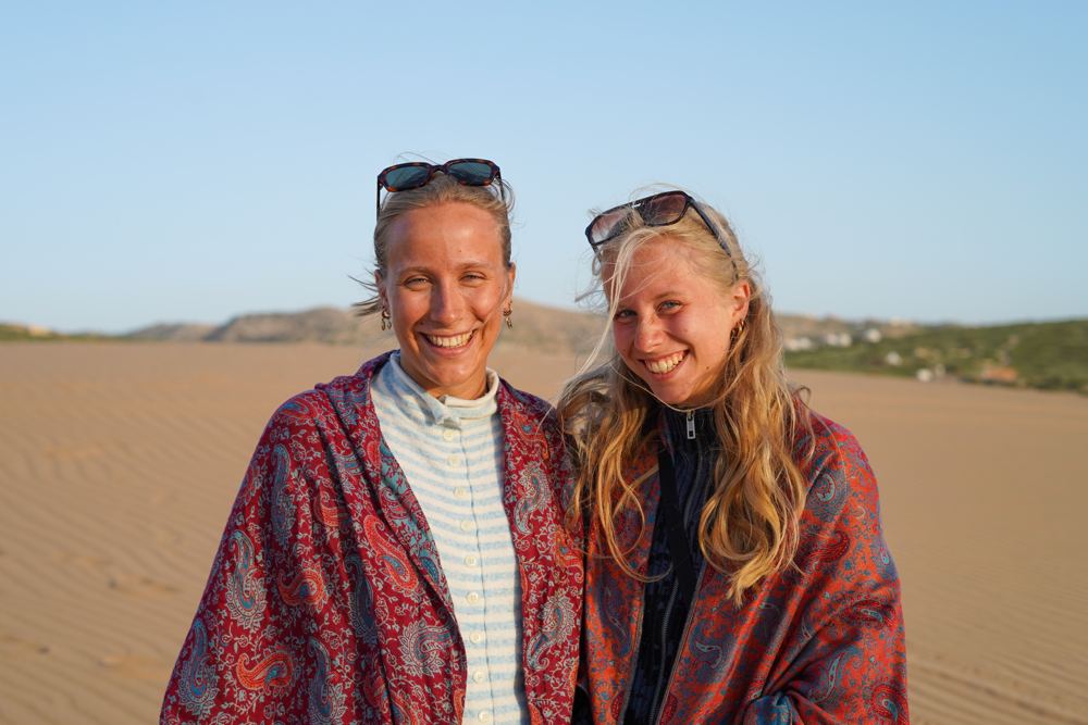 Deux amies souriantes, châles et lunettes sur la tête