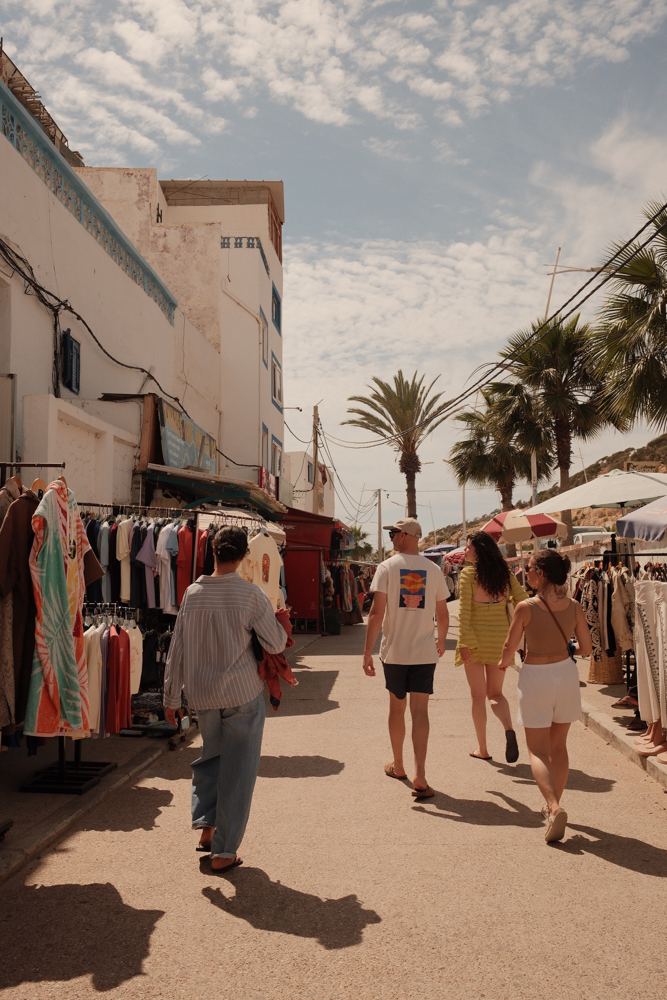 Promenade du marché, portants de vêtements et palmiers