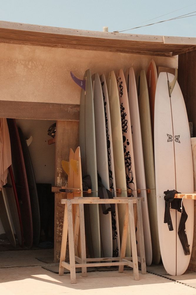 Planches de surf rangées contre un mur ocre