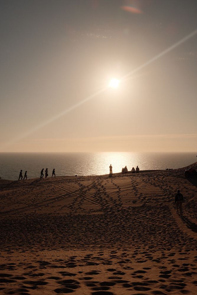 Soleil bas sur la dune, silhouettes sur la crête